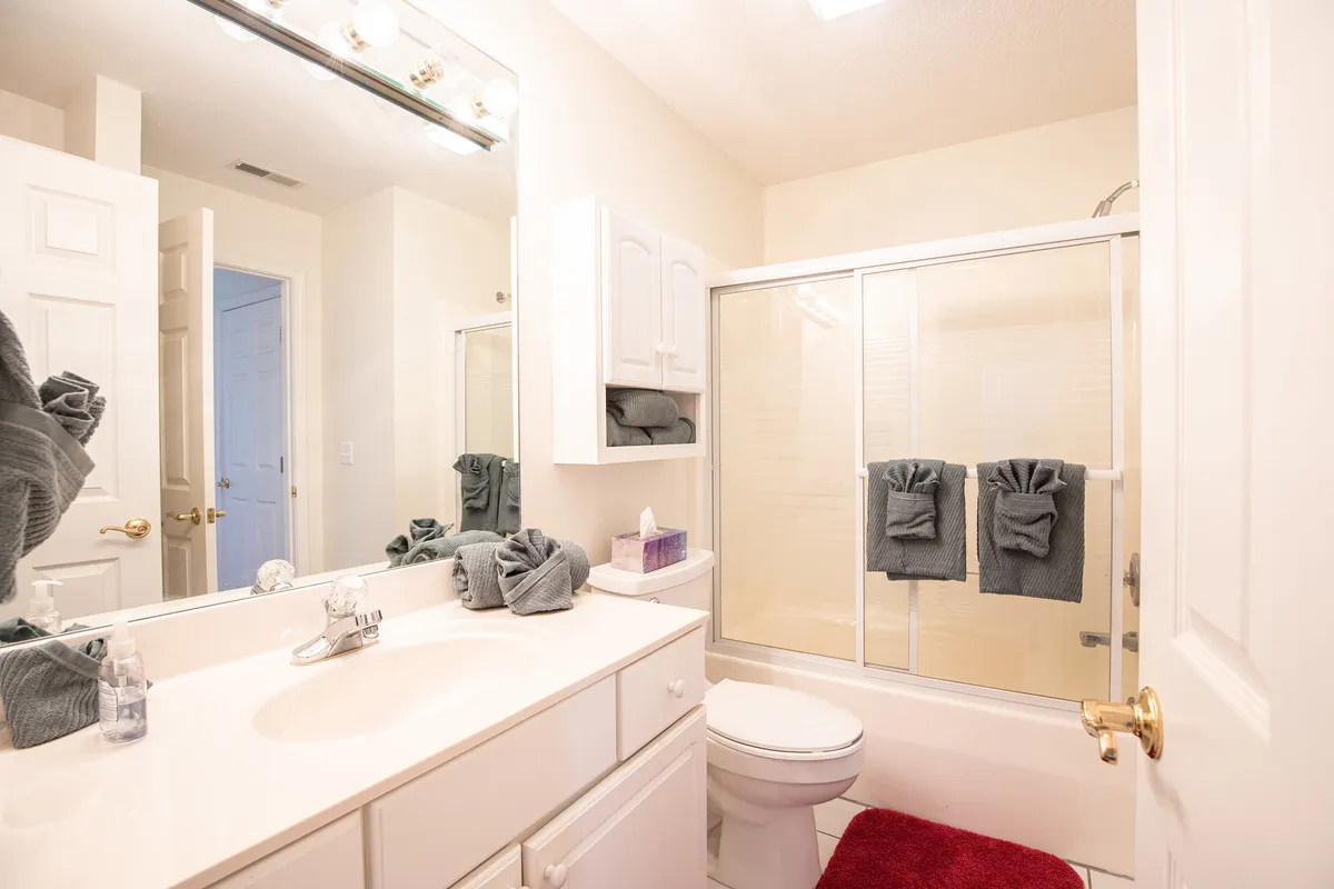 A fresh and organized bathroom with a vanity, sink, shower area, and mirrored cabinet. The clean design and tidy arrangement make the space ideal for feeling at home and cared for, with toiletries and essentials likely stocked as promised.