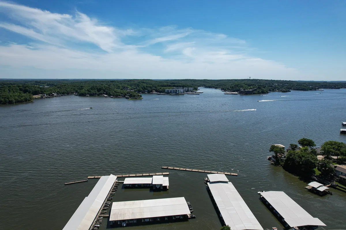 A sweeping view of the lake, with docks, boathouses, and the horizon stretching out in the background. The tranquil scene invites exploration and highlights the serene atmosphere, perfect for boating, fishing, or simply unwinding by the water.